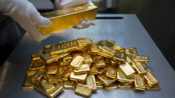 Gold bars being handled in a secure vault